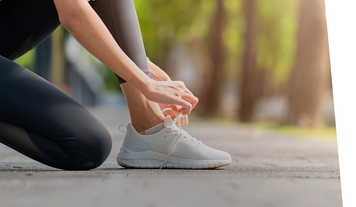 woman tying her laces on her sneakers